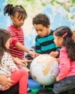 preschoolers looking at a globe